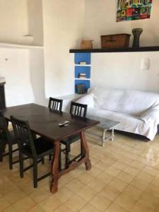 1 dormitorio con mesa, sillas y 1 cama en CALA SERENA BEACH 5, en Cala Serena 16 fotos más