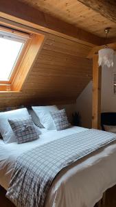 una camera da letto con un grande letto bianco e una finestra di Le Nid de Cigognes a Hengwiller