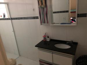 ein Badezimmer mit Waschbecken und Spiegel in der Unterkunft Casa Ampla e Confortável a 10 minutos Praia Ubatumirim Cambuca in Ubatuba