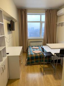 a small room with a bed and a table and chairs at BYSmartHouse in Kyiv