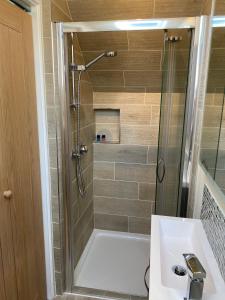 a bathroom with a shower and a white bath tub at Bagpuss Cottage Stunning 2 bedroom cosy cottage in Witney