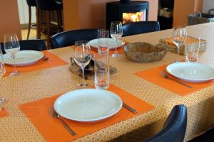 una mesa con platos, tenedores y vasos. en Rod Hus, en Sourbrodt