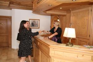 two women standing at a counter in a room at Hotel-Restaurant Hirsch in Berghaupten