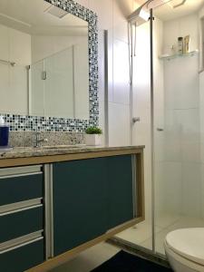 a bathroom with a shower and a sink and a toilet at Lindo apartamento Riverside Imbassaí in Imbassai