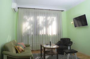 a living room with a couch and a chair and a table at Midtown Place Apartment DORIS 1 with garage in Plovdiv