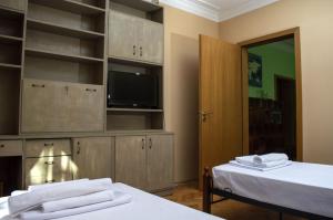 a room with two beds and a tv and shelves at Midtown Place Apartment DORIS 1 with garage in Plovdiv
