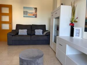 sala de estar con sofá y taburete en Playas de cabo, en Retamar