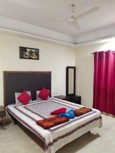 a bedroom with a large bed with red pillows at Whistling Waves Beach Resort in Ānjarle