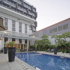 a hotel swimming pool in front of a building at Howard Johnson By Wyndham Pekalongan in Pekalongan