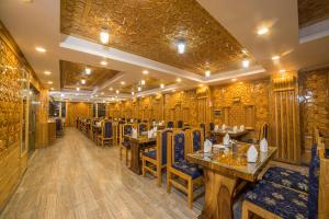 um restaurante com paredes e mesas e cadeiras de madeira em OPERA INN em Srinagar
