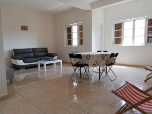 a living room with a couch and a table and chairs at Résidence Yô in Mindelo