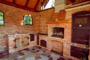 a large brick kitchen with a brick fireplace at Apartament na Mazurach in Ostróda