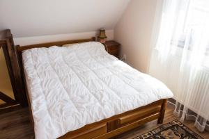 una camera da letto con un letto con lenzuola bianche e una finestra di Apartament na Mazurach a Ostróda