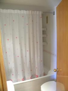 baño con cortina de ducha con lunares rosas en Apartamentos Decathlon Arysal, en Salou