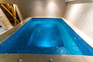 una gran piscina de agua azul en una habitación en Семеен хотел АРИЗОНА, en Pavel Banya