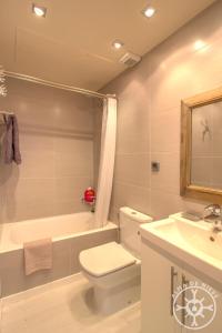 a bathroom with a toilet and a tub and a sink at BICIBERRI de Alma de Nieve in Baqueira-Beret