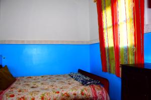 a blue bedroom with a bed and a window at Gîte Tamsoulte in Imlil