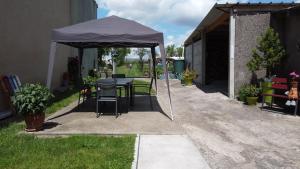 Tienda negra con mesa y sillas en un patio en gite de plaisance en Lagarde