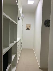 a hallway with white shelving and a white wall at Metropolitan Sidney Smart Style in Goiânia