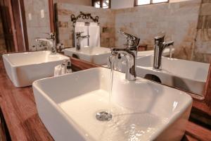 a bathroom with two sinks and two faucets at Ngorongoro Marera Mountain View Lodge in Karatu +64 photos