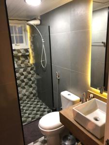 a bathroom with a toilet and a shower and a sink at Lindo Flat em Maresias, 100m da Praia in Maresias +21 photos