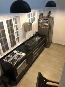 a kitchen with a stove and a refrigerator at Lindo Flat em Maresias, 100m da Praia in Maresias