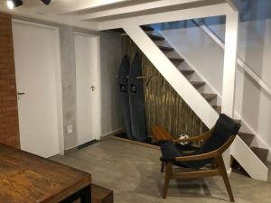 a room with a table and a chair and a staircase at Lindo Flat em Maresias, 100m da Praia in Maresias