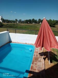 una sombrilla roja sentada junto a una piscina en Cabaña Abuelo Ernesto 1 en Colón