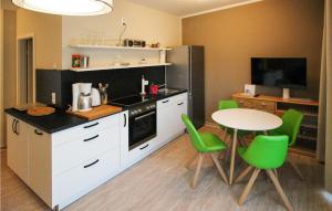 cocina con mesa y sillas verdes en Stunning Apartment In Graal-mritz With Kitchen, en Graal-Müritz