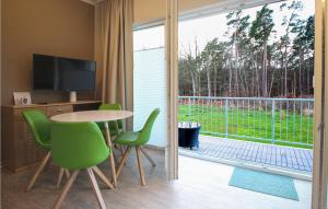 Habitación con mesa, sillas y puerta corredera de cristal. en Stunning Apartment In Graal-mritz With Kitchen, en Graal-Müritz