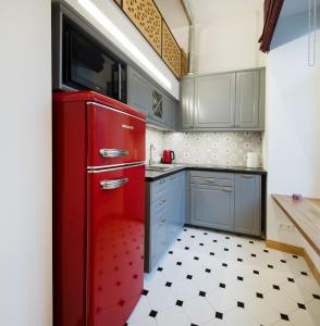 een rode koelkast in een keuken met een zwart-witte vloer bij Tiltų 5 Studio in Klaipėda