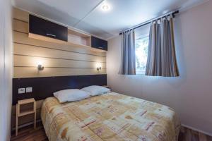 Un dormitorio con una cama grande y una ventana en L'Oasis, en Grospierres