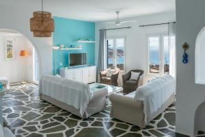 a living room with two chairs and a tv at Villa Tani in Agios Georgios