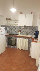 a kitchen with white cabinets and a tile floor at Casa del Parlamento in Palermo