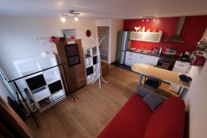 un soggiorno con divano rosso e una cucina di Libellules a Villeneuve