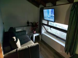 a living room with a couch and a flat screen tv at Danailovi Guest House in Sapareva Banya