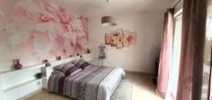 Oeyreluy的住宿－Chambres d'Hôtes Etang de l'aiguille，一间卧室设有一张床和粉红色的花墙