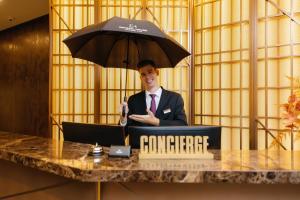 a man in a suit holding an umbrella next to a table at Crystal House Suite Hotel & SPA in Kaliningrad
