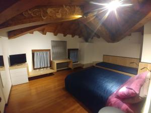 a bedroom with a blue bed and a television at B&B Mirò in Pieve di Soligo
