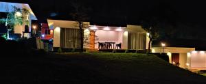 a house at night with a table and chairs at Peakaavu Cottages in Idukki