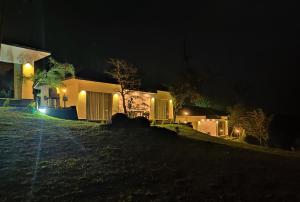 a house lit up at night with lights at Peakaavu Cottages in Idukki