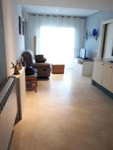 a living room with a large window and a large tile floor at Apartamento en la costa brava in Palafrugell