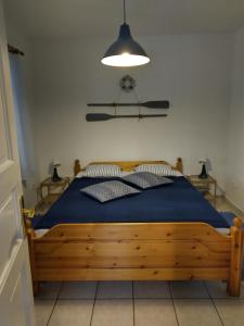 レーヴフュロップにあるSirály Apartmanのベッドルーム1室(青いシーツと照明付きのベッド1台付)