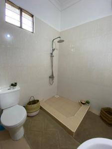 a bathroom with a toilet and a shower in it at Pumzika Kendwa Villa in Kendwa
