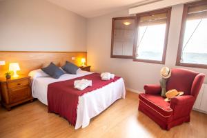 a bedroom with a bed and a red chair at Apartamento Rural New Folch in Morella