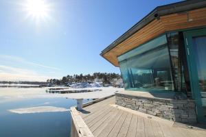 a house with glassdoors and a table on a deck at Holmen Fjordhotell in Nes