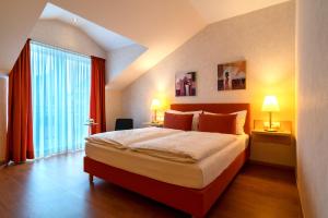 a bedroom with a large bed and a large window at Hotel Engbert in Oelde