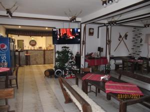 a restaurant with tables and chairs and a christmas tree at Guest House Belchin View in Belchin