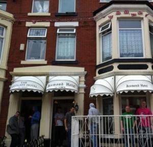 ブラックプールにあるJesmond International Hotelの建物の外に立っている人々のグループ