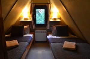 Habitación pequeña con 2 camas en una tienda en Chata s wellness, en Hutisko